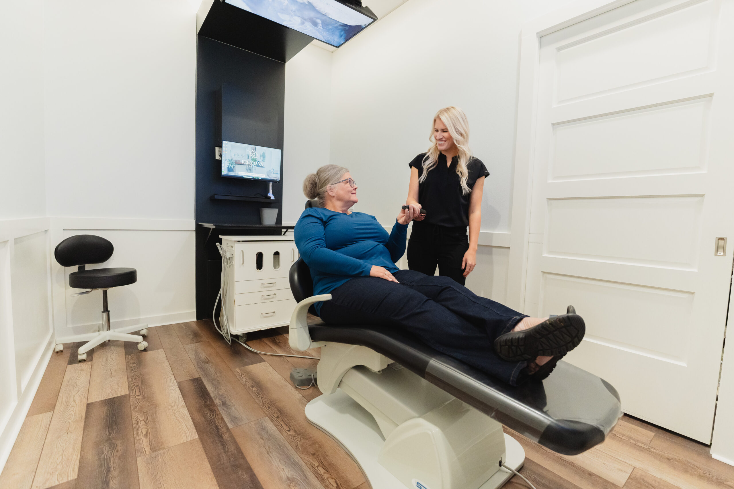 nice, happy dental assistant providing patient with remote to tv in patient room at Feliciana dental in St Francisville, LA 70775